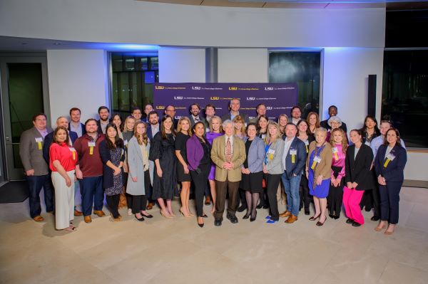 A large group of people standing in front of a purple banner with COB logo.
