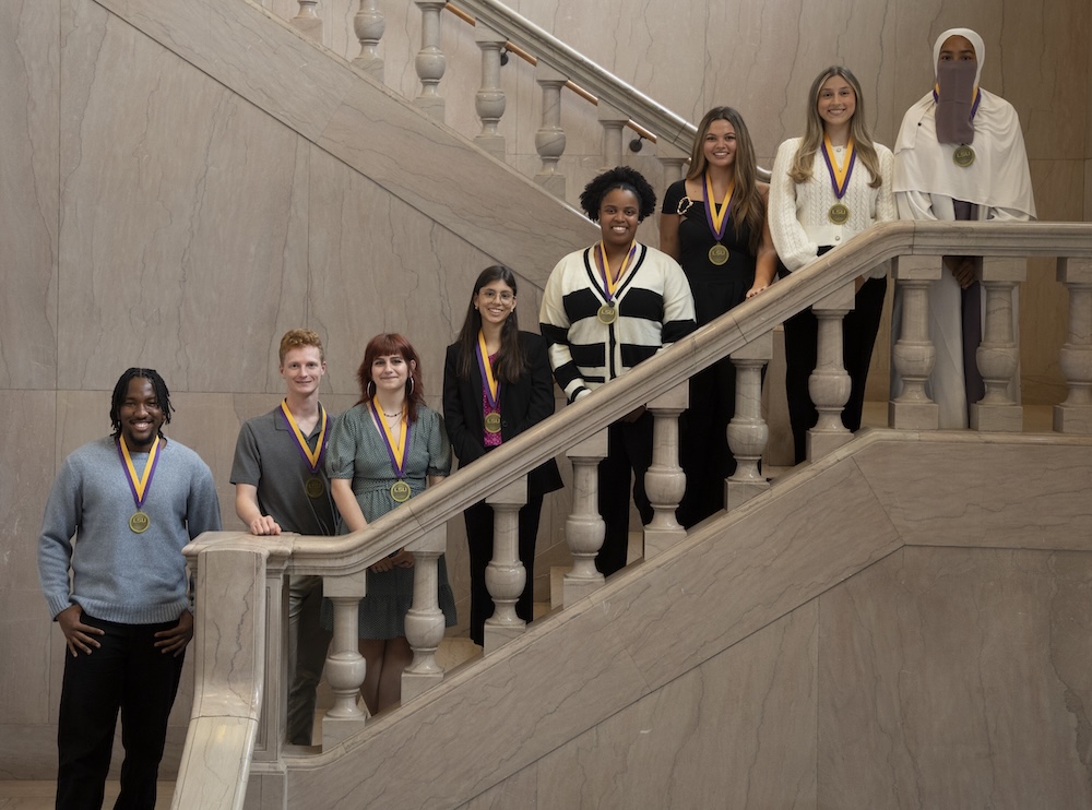 Eight medalists standing along a staircase